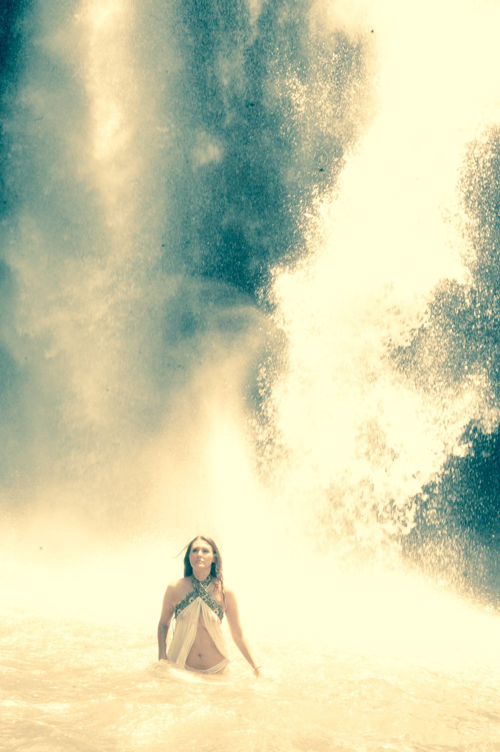Photograph by Heather Brand: a woman small in the frame, rising from water into a vast haze of white light and spray.