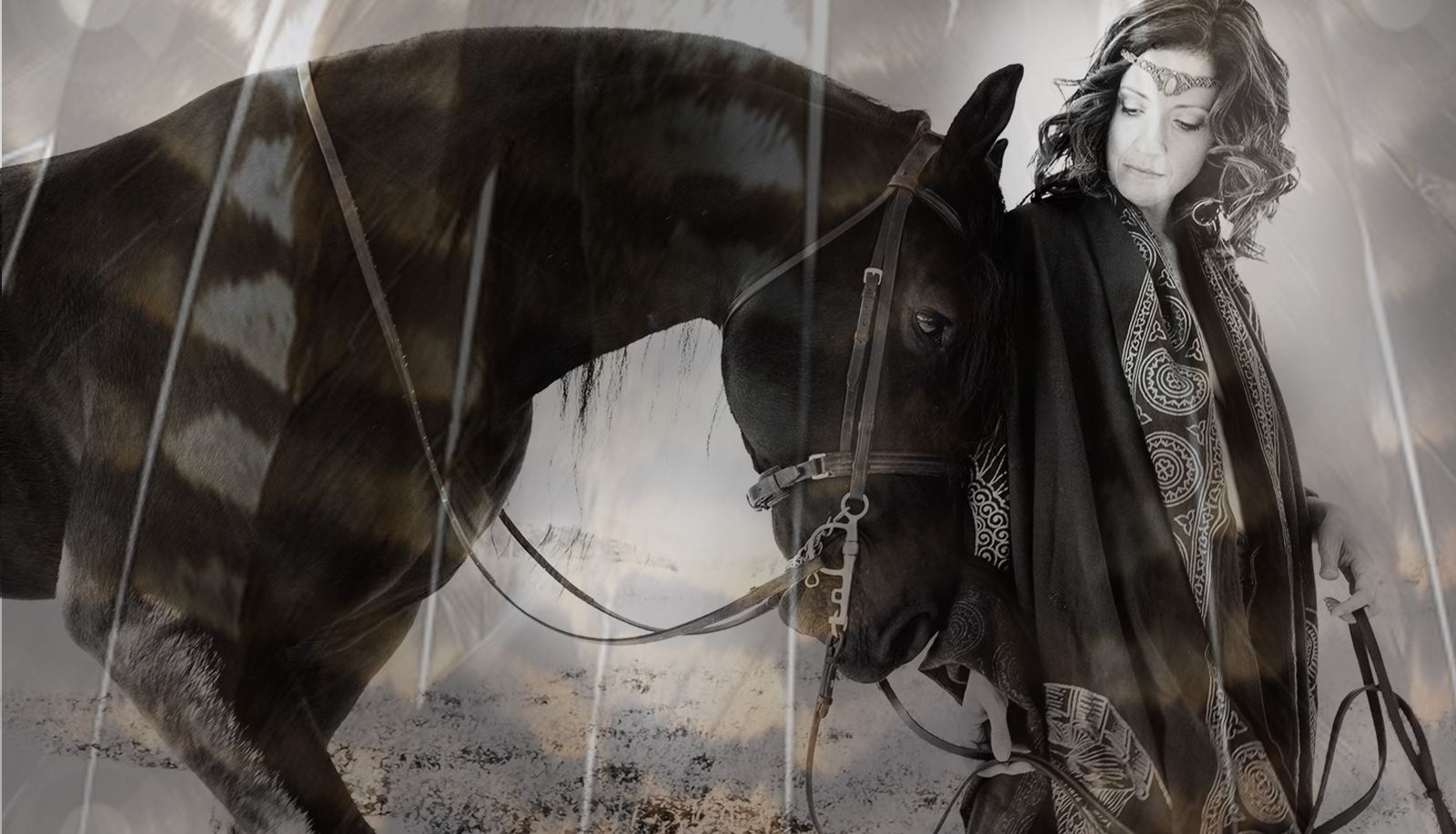 Black and white photograph by Heather Brand: a woman in a patterned cloak and headpiece stands with her head bowed against a dark horse, rain streaking the air.